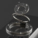 Silver ring holder with gemstone accents on a reflective surface