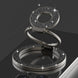 Silver ring holder with gemstone accents on a reflective surface