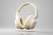 Beige headphones with Baseus logo and 'Hi-Res Audio' text on a gradient background
